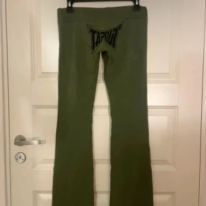 Gröna byxor från Tapout - Snygga gröna byxor från Tapout med logga både fram och bak. Byxorna har en bootcut-stil och snörning i midjan för justerbar passform. Perfekta för en avslappnad look. Gamla bilder från förra säljaren då dom inte passade på mig 💓
