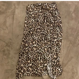 Leopardmönstrad kjol från New Yorker - Snygg leopardmönstrad långkjol från New yorker. Kjolen har en slits som ger en extra touch och är perfekt för att sticka ut. Tillverkad i ett lätt och bekvämt material som passar bra för olika tillfällen.