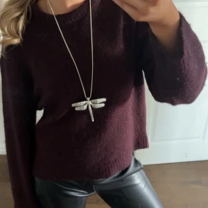 Silverfärgat halsband med trollslända - Elegant silverfärgat halsband med en detaljrik trollslända som hänge. Perfekt för att ge en stilren touch till din outfit. Kedjan är lång och smal, vilket gör den lätt att bära till olika tillfällen.