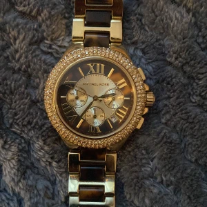 Michael kors klocka  - Äkta Michael kors klocka, bra skick, köpt förra året men batteriet har tagit slut använt den för syftet till mode:) 