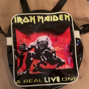 Iron maiden väska - Cool Iron maiden merch ifrån en av deras konserter på 80-90 talet. Ganska använd och dragkedjan är trasig(går att laga). Får plats med mycket i den.
