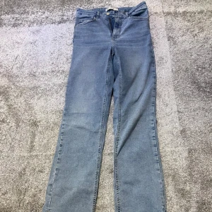 Blåa högmidjade jeans med slits - Blåa högmidjade jeans med slits. En fläck vid slutet av byxan men annars bra skick. Priset diskuteras pga fläcken