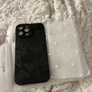 Nya mobilskal - Säljer två snygga mobilskal! Ett svart skal med fjärilsmönster och ett genomskinligt med vita hjärtan. Båda skalen är helt nya. Jag råka beställa för fel modell, och orkade ej skicka tillbaka. Passar iPhone 13 Pro Max.