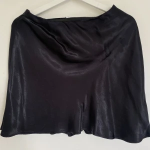 Svart satin kjol från H&M!🫶🏻✨ - Säljer en mini kjol i satin från H&M i storlek S. Kjolen är helt oanvänd! Passar perfekt till strumbyxor, en svart blus och höga boots nu till hösten!🫶🏻🎀✨
