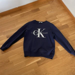 Långärmad tröja Calvin Klein Jeans - Blå långärmad tröja från Calvin Klein Jeans. Djur- och rökfritt hem.