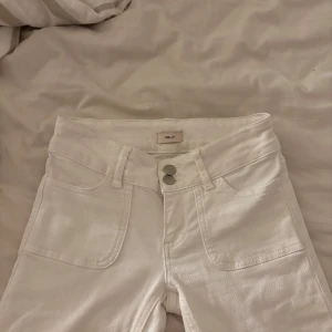Vita jeansbyxor från Nils - Snygga vita låg midjade jeans ifrån Nelly. Bootcut och använt ett fåtal gånger. Säljer då de är för små. 
