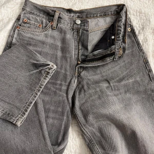 Grå jeansbyxor - Snygga grå jeansbyxor från Zara med en loose passform. Byxorna har en klassisk femficksdesign och stängs med dragkedja och knapp. Perfekta för en avslappnad stil.