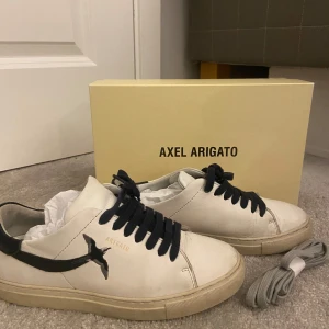 Vita sneakers från Axel Arigato   - Snygga vita sneakers från Axel Arigato i bra skick kommer med extra gråa skosnören pris kan diskuteras skriv om ni har några frågor 