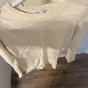 Vit stickad tröja från Vila - Säljer en stilren vit stickad tröja från Vila. Tröjan har en rund halsringning och långa ärmar, perfekt för kyligare dagar. Den är mjuk och bekväm, vilket gör den till ett mångsidigt tillskott i garderoben. Passar bra till både jeans och kjol. 🧶✨
