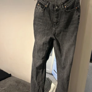 Svart-gråa  jeansbyxor - Snygga svarta jeansbyxor med klassisk femficksdesign och knappgylf. Perfekta för en stilren look. 