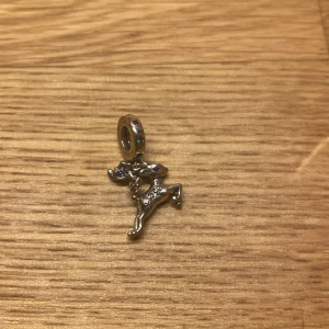 Pandora berlock - En liten ren Pandora berlock med blåa, röda och gröna stenar. Det står ”magic is in the air” på renen. 