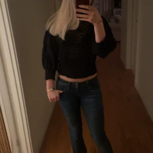 Svart croppad topp - Snygg svart croppad topp med trekvartsärm och ett subtilt mönster. Perfekt för en trendig look. Passar bra till jeans eller kjol.