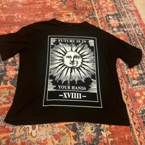 Svart t-shirt med soltryck - Cool svart t-shirt med ett stort tryck av en sol och texten 'Future is in your hands - XVIII'. 