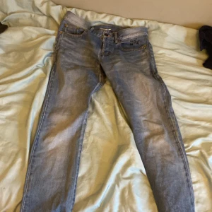 Blå jeans från Saint Laurent - Snygga blå jeans från Saint Laurent med klassisk femficksdesign och broderad logga på fickan. De har en straight passform och är tillverkade i högkvalitativt denim. Perfekta för en stilren look.