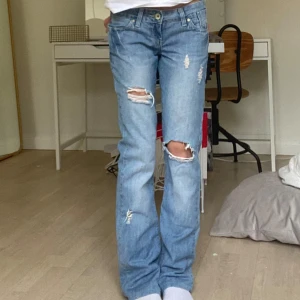Low waist jeans - Säljer ett par lågmidjade jeans med slitningar💗mått: Midjemått 36cm, innerbenslängden 77cm, Grenen 17cm, höftvidden 40 cm
