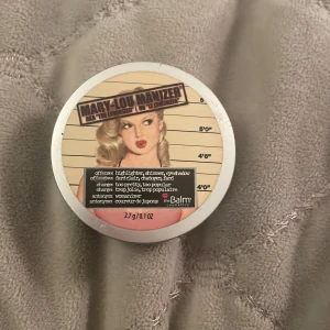 Mary-Lou Manizer Highlighter från theBalm - Säljer en Mary-Lou Manizer highlighter från theBalm. Den har en ljus champagnefärg som ger en fin lyster till huden. Perfekt för att framhäva kindben och andra ansiktsdrag. Kompakt förpackning med spegel, lätt att ta med sig.