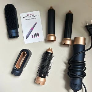 Multifunktionell varmluftsborste med tillbehör - Säljer en mångsidig varmluftsborste med flera utbytbara tillbehör för olika stylingbehov. Setet inkluderar olika borstar och munstycken, allt förpackat i ett elegant blått fodral. Perfekt för att skapa volym och lockar med enkelhet.