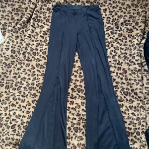 Svarta bootcut byxor - Snygga svarta byxor med vida ben. Perfekta för en stilren look. Materialet är mjukt och bekvämt, vilket gör dem idealiska för både avslappnade och mer uppklädda tillfällen.