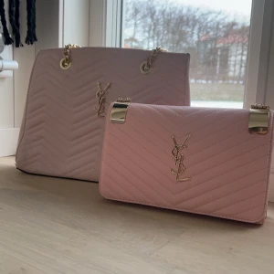Rosa väskor YSL - Två eleganta rosa väskor med quiltad design och guldfärgade detaljer. Perfekta för att ge en lyxig touch till din outfit. Den större väskan har kedjehandtag och den mindre är en  kuvertväska. Båda är fejk asså inte äkta!!!!