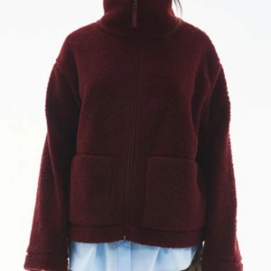 Ny vinröd teddyjacka med dragkedja i stl S från H&M - Helt ny och oanvänd . Mysig vinröd teddyjacka pilejacka med dragkedja framtill. Jackan har en hög krage och två stora fickor. Perfekt för kyliga dagar. Storlek S