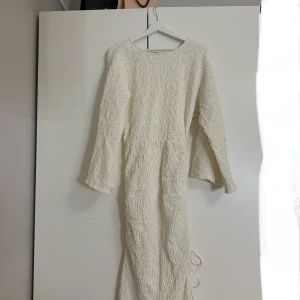 Vit långklänning med struktur - Så himla snygg vit långklänning med texturerat material och långa ärmar.💞Klänningen har en såå snygg passform och en subtil slits på sidan som går att justera. Den är även väldigt lång, jag är 170 och den går hela vägen ner till marken. Perfekt för speciella tillfällen. Tyvärr aldrig använd för jag fick hem fel storlek, så den är helt ny! Orginalpris 800kr!🙌🏽