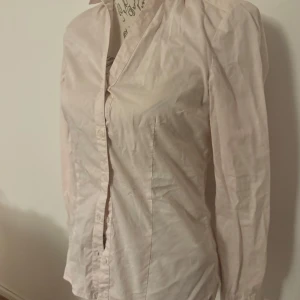 Ljusrosa blus från H&M - Säljer en stilren ljusrosa blus från H&M. Blusen har en klassisk krage och knappar framtill. Perfekt för en elegant look.