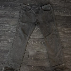 Grå Levis 501 jeans - Säljer mina Levis 501 köpta på nk i Göteborg. Kvitto och påse finns fortfarande. Dom är fortfarande i ny kondition förutom att det är lite slitna nere vid hälen men inget man ser direkt. Fråga bara om ni vill ha flera bild osv.  Köpta för 1200kr