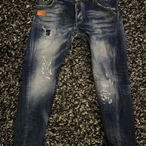 Blå jeans från Dsquared2 - Snygga blå jeans från Dsquared2 som jag inte längre använder. Slitningarna är riktigt feta och den passar storlek 32. Riktigt sköna jeans. Priset är inte hugget i sten kan gå ner vid snabb affär.