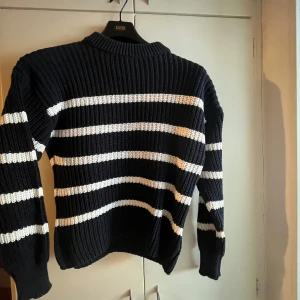 Blå och vit randig tröja - Säljer en blå o vit randig tröja som nästan är helt oanvänd. Tröjan har en ribbadstruktur. Storlek M
