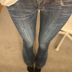 Blå jeans med gula detaljer - Snygga blå jeans från Victoria Beckham med unika guldiga detaljer på bakfickorna. De har en klassisk femficksdesign och en bekväm passform. låg midjade 25/32 är 170 och det sitter bra. pris kan diskuteras 💞💞