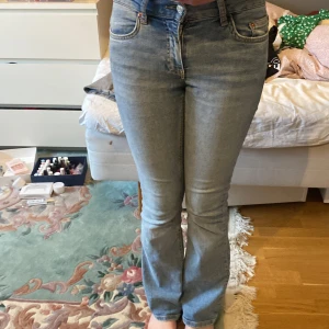 Blå jeans från Gina tricot - Snygga blå jeans från Gina tricot med en klassisk design. De har en bekväm passform och är perfekta för en avslappnad stil. Jeansen har en traditionell femficksmodell och en knappgylf.