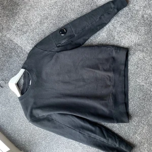 Svart tröja från C.P. Company - Säljer en stilren svart tröja från C.P. Company. Tröjan är i storlek S. hör av er vid frågor!