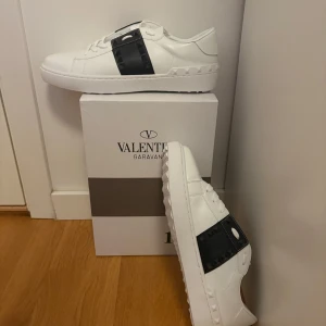 Valentino skor - Snygga vita Valentino Garavani sneakers med svarta detaljer. Skorna har en stilren design med snörning och en robust sula. Perfekta för en trendig look. Skick✅(9/10) Använd ett par få gånger👍 OBS jag står inte för fraktens slarv‼️