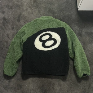 Stussy 8-ball sherpa - Säljer denna juvel ur kollektionen då den inte använt på över 1 år. Fleecen köptes precis efter släpp på en resell butik i London 2022. Jackan är strl L och är reversable. Sjukt fint skick använd fåtal gånger. Har tyvärr ingen fysiskt kvitto kvar. Skriv gärna vid intresse och frågor. Pris ej hugget i sten vid chill affär!
