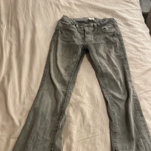 Grå jeans från Gina Tricot - Snygga grå jeans från Gina Tricot ❤️med bootcut-stil. De har dekorativa bakfickor med vita sömmar och en klassisk femficksdesign. Perfekta för en avslappnad look.