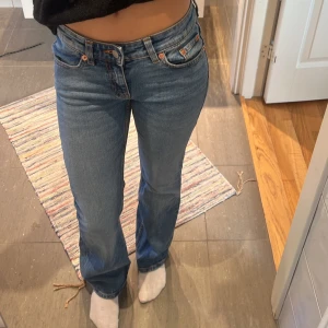 Blå jeans med bootcut - Snygga blå jeans med bootcut-stil och klassisk femficksdesign. Perfekta för en avslappnad look. De har en knapp- och dragkedjestängning framtill.