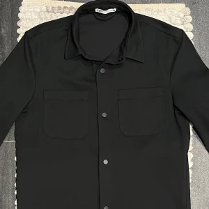Zara Overshirt Svart - Snygg svart Overshirt från Zara med klassisk krage och knappar framtill || Storlek: M || Mycket fint skick 