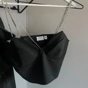 Korsettopp - Snygg svart korsettopp från VILA med glittriga axelband. Använd en gång.