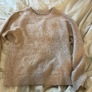 Beige stickad tröja från Vero Moda - Mysig beige stickad tröja från Vero Moda. Perfekt för kyliga dagar med sin mjuka och bekväma design. Tröjan har långa ärmar och ribbade kanter vid ärmslut och nederkant.