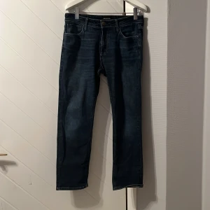 Mörkblå jeans från Jack & Jones - Snygga mörkblå jeans från Jack & Jones med klassisk femficksdesign. Väldigt moderna jeans med passformen regular och är stretchig. Storleken är 33/30. Dem är välanvänd men har inga skavanker på nått sätt. Skicket är 9/10. Dem är köpt för 800kr ordinarie pris.