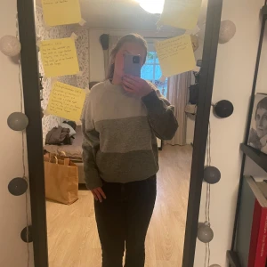 Bredrandig stickad tröja från H&M - Säljer en mysig gråmelerad stickad tröja från H&M. Tröjan har en rund hals och långa ärmar med ribbade muddar. Tre nyanser av grå och är lite oversized. Tröjan är relativt tunn och inte speciellt varmt och passar lika bra på vintern som på sommaren.
