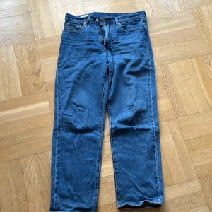 Blå jeans från Levi Strauss & Co. - Säljer ett par klassiska blå jeans från Levi Strauss & Co. med en straight passform. De har en traditionell femficksdesign och en knappgylf. Perfekta för en avslappnad stil.