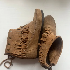 Bruna mockaboots med fransar - Säljer ett par bruna mockaboots med fransar och dekorativa nitar. De har ca 5 mc klack och är i storlek 40💞💞
