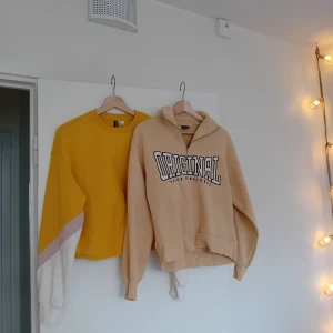 Gul tröja och beige hoodie med tryck - Säljer en gul tröja med vita och rosa detaljer på ärmarna samt en beige hoodie med texten 'ORIGINAL' tryckt på framsidan. Hoodien har en dragkedja vid halsen och båda plaggen har långa ärmar. Perfekta för en avslappnad stil!