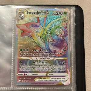 Serperior VSTAR Pokémonkort - Säljer ett glittrande Serperior VSTAR Pokémonkort med 270 HP. Kortet har en färgglad design med en regnbågsskimrande yta. Det har attacker som Regal Blender och Star Winder. Perfekt för samlare eller Pokémon TCG-spelare som vill stärka sin kortlek. Kortet är i fint skick och förvaras i en plastficka för extra skydd. Vet inte hur mkt den går för så lägg bud!