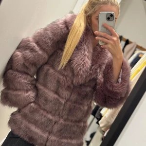 Lila pälsjacka - Säljer en lyxig lila pälsjacka med mjuk och fluffig textur. Jackan har långa ärmar och ett elegant mönstrat foder. På mig är den pälsjackan oversize, min storlek är XS-S och jag är 163 cm lång. Pälsjackan passar även för storlek M. Den pälsjackan stängs med 3 öglor.