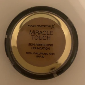 Miracle Touch Foundation från Max Factor -  Helt ny Säljer en Max Factor Miracle Touch Skin Perfecting Foundation med hyaluronsyra och SPF 30. Perfekt för en jämn och felfri hy. Kompakt förpackning som är lätt att ta med sig.