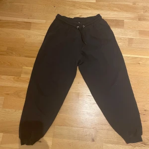 Svarta mjukisbyxor från lager 157 - Säljer ett par svarta mjukisbyxor från lager 157 i storlek S. Byxorna har en elastisk midja med snörning för justerbar passform och ribbade muddar vid bensluten.