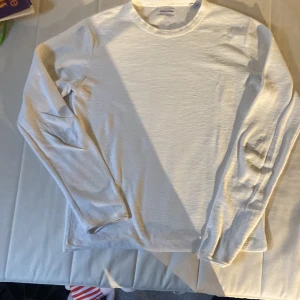 Vit långärmad tröja från Jack & Jones - Säljer en stilren vit långärmad tröja från Jack & Jones. Riktigt stilig och grisch. Den är gjord av mjukt bomulls och linen material som är skönt mot huden. Passar perfekt till jeans eller chinos för en avslappnad look.