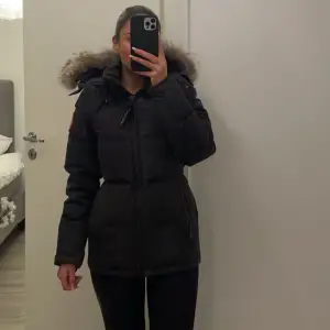 Säljer en snygg och varm svart dunjacka från Canada Goose. Jackan har en avtagbar huva med pälsdetaljer och en dragkedja framtill. Går även att dra åt ett band i midjan för att få den mer figurformad. Ordinarie pris:  17 790kr. Skriv för fler bilder  🖤Endast seriösa köpare, inga skambud 